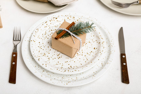 Christmas table setting with fir branch and cinnamon on white background, closeup