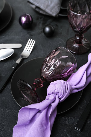 Beautiful table setting with Christmas balls on black background, closeupの写真素材
