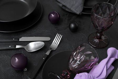 Beautiful table setting with Christmas balls on black background, closeupの写真素材