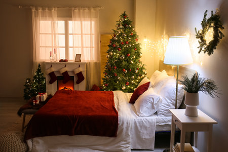 Interior of bedroom with glowing Christmas trees and fireplaceの写真素材
