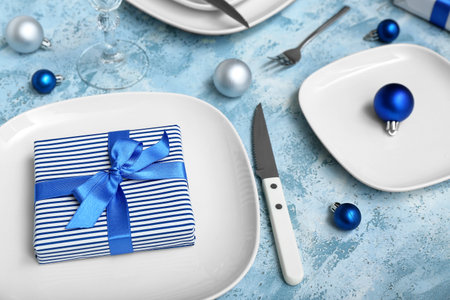 Beautiful table setting with Christmas balls and gift on grunge background, closeupの写真素材