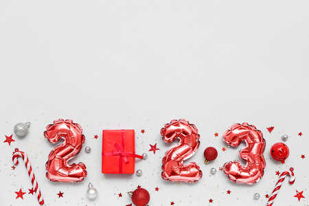 Figure 2023 made of balloons, Christmas decorations and gift white background