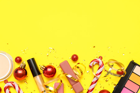 Makeup products with Christmas decor on yellow backgroundの写真素材