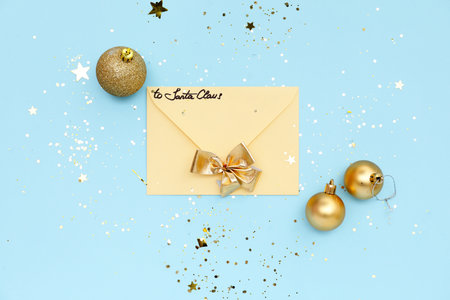 Letter to Santa with Christmas balls, bow and confetti on blue background
