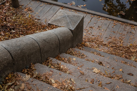 View of granite stairs with fallen leaves in autumn park
