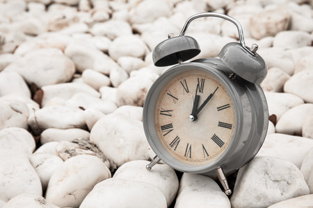 Vintage alarm clock on white stones, closeupの写真素材