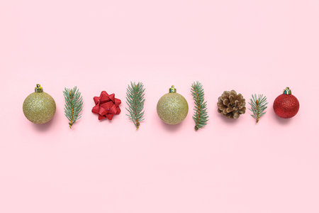 Composition with Christmas decorations and fir branches on pink backgroundの写真素材
