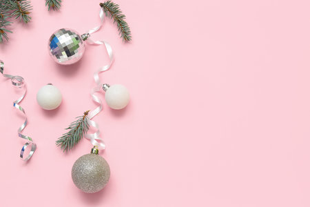 Composition with beautiful Christmas balls, serpentine and fir branches on pink backgroundの写真素材