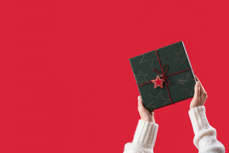 Woman with Christmas present on red background