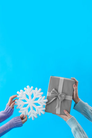 Women with Christmas gift box and snowflake on blue backgroundの写真素材