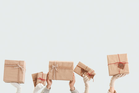 People with Christmas gift boxes on gray background