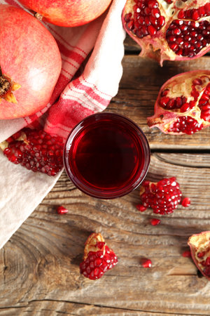 Glass of tasty pomegranate juice and fresh fruits on wooden backgroundの写真素材