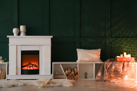 Interior of dark living room with fireplace, burning candles and shelving unitsの写真素材