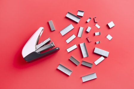 Stapler with staples on red background