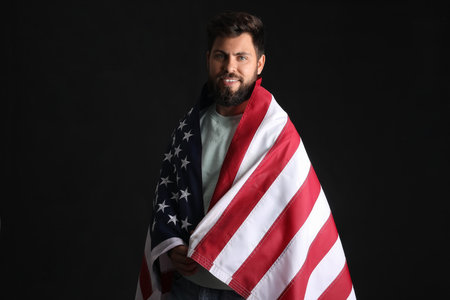 Handsome bearded man with USA flag on black background