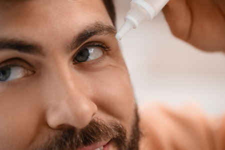 Handsome man using eye drops, closeupの写真素材