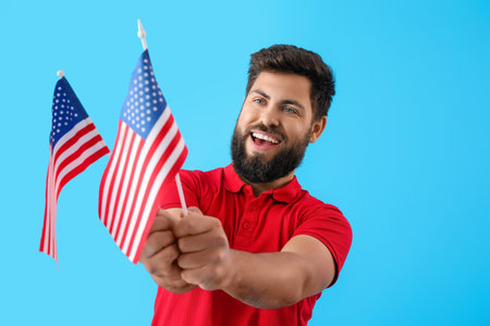 Handsome bearded man with USA flags on blue backgroundの写真素材