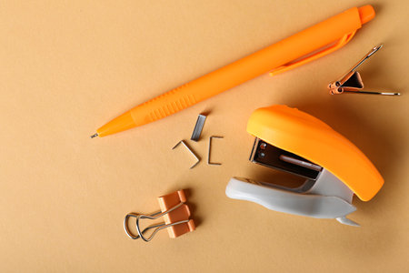 Office stapler, pen and paper clips on color backgroundの写真素材