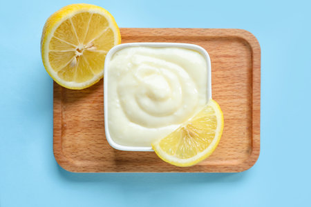 Board with bowl of tasty pudding and lemon on blue backgroundの写真素材