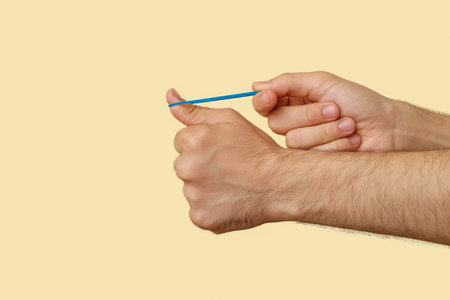Man with blue rubber band on beige backgroundの写真素材