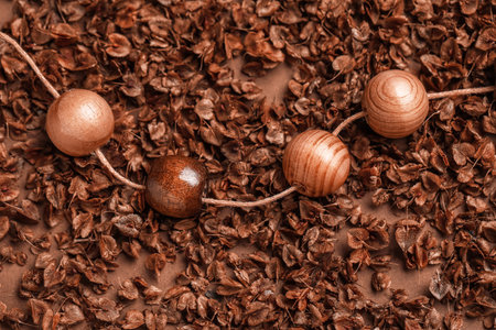 Thread with wooden beads on brown backgroundの写真素材