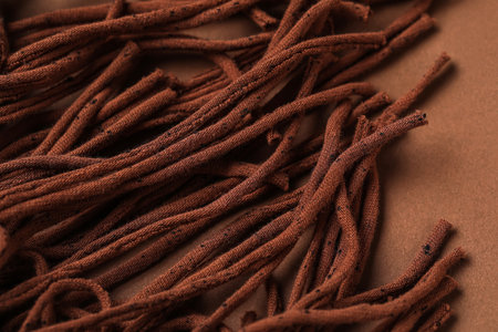 Fabric tassels on brown background