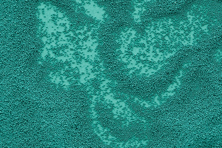 Small beads scattered on green backgroundの写真素材