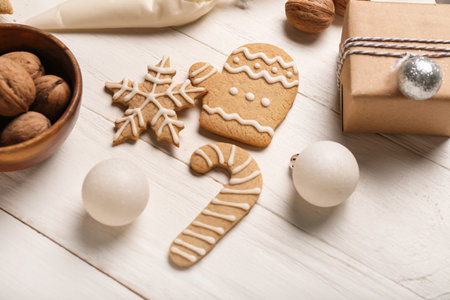 Tasty Christmas cookies, decorations and gift on light wooden backgroundの写真素材