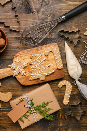 Composition with tasty Christmas cookies, gift and utensils on wooden backgroundの写真素材
