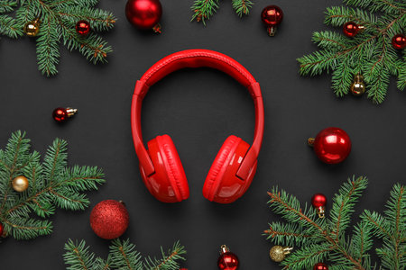 Composition with modern headphones, Christmas balls and fir branches on dark backgroundの写真素材