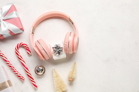 Composition with modern headphones, Christmas gifts, decorations and candy canes on light backgroundの写真素材