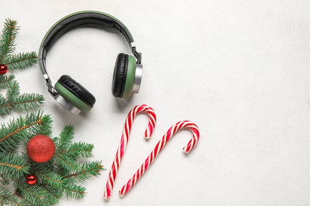 Composition with modern headphones, fir branches and candy canes on light backgroundの写真素材