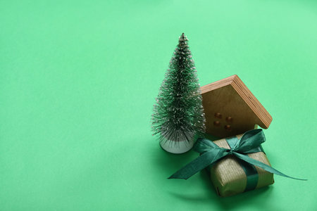 Christmas tree with gift and house figure on green backgroundの写真素材