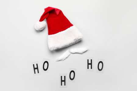 Santa hat with mustache made of cotton wool and words HO HO HO on gray backgroundの写真素材