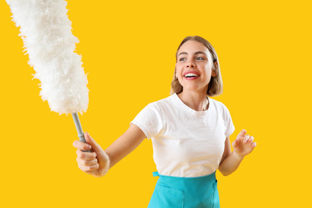 Pretty woman with duster on yellow backgroundの写真素材