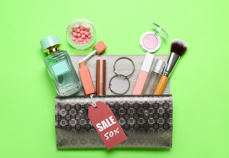 Wallet with cosmetics, accessories and sale tag on green backgroundの写真素材