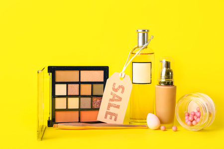 Cosmetic products and accessories with sale tag on yellow backgroundの写真素材