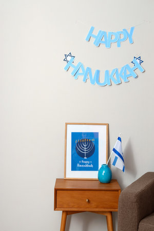 Table with picture, Israel flag and text HAPPY HANUKKAH on light wallの写真素材