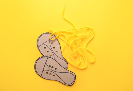 Shoe lacing cards with laces on yellow backgroundの写真素材