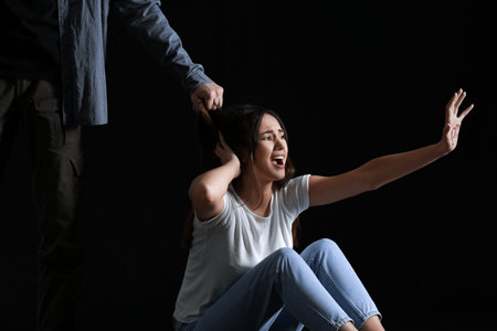 Man and his victim on dark background. Violence concept