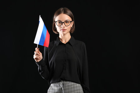 Beautiful young woman with flag of Russia on dark backgroundの写真素材