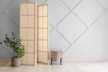Stylish folding screen in room interior on wall backgroundの写真素材