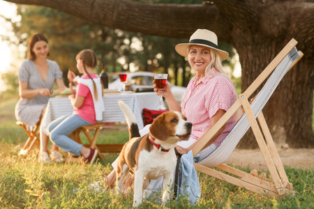 Family with cute dog at barbecue party outdoorsの写真素材