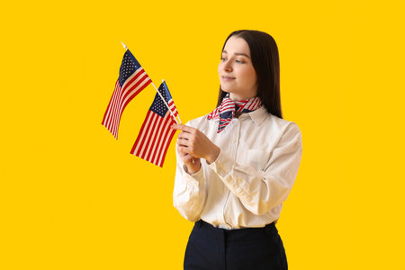 Young woman with USA flags on yellow backgroundの写真素材