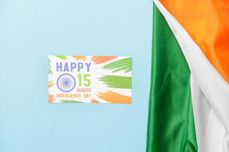 Indian flag and greeting card for Independence Day on color background