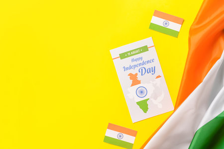 Indian flags and greeting card for Independence Day on color background