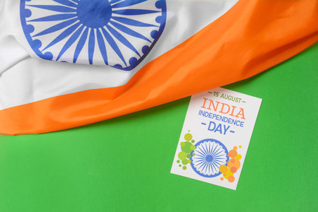 Indian flag and greeting card for Independence Day on color background