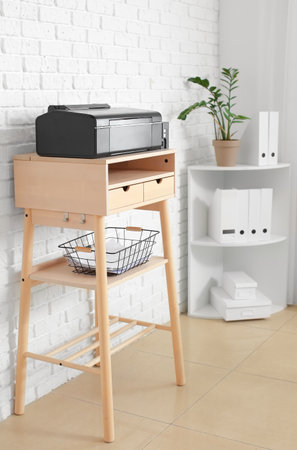 Interior of modern room with standing desk and printer near white brick wallの写真素材