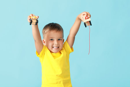 Cute little boy with wooden toys on blue backgroundの写真素材