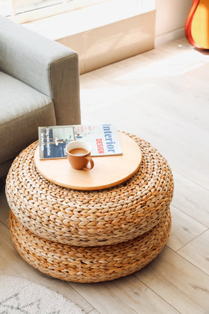 Rattan poufs with cup of coffee and magazine in living roomの写真素材